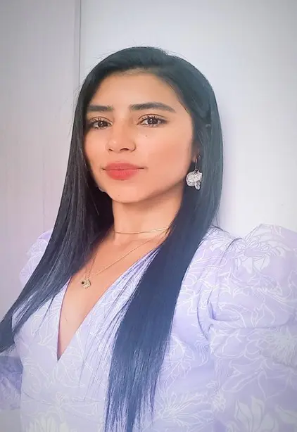 Portrait of a woman with long black hair in a light purple blouse.