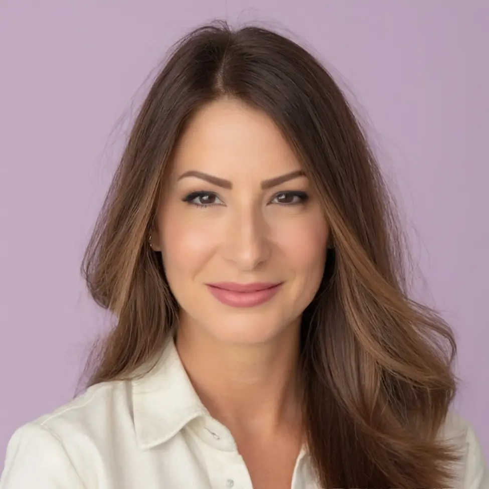 Professional headshot of a woman with long brown hair and a white blouse.